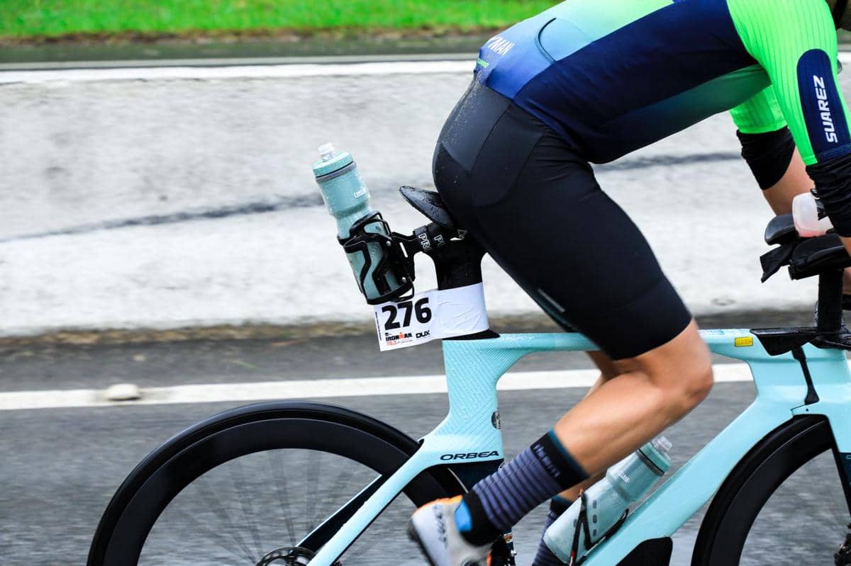 Ilustrasi bottle cage dengan botol minum yang terpasang pada rangka sepeda untuk kebutuhan bersepeda.
