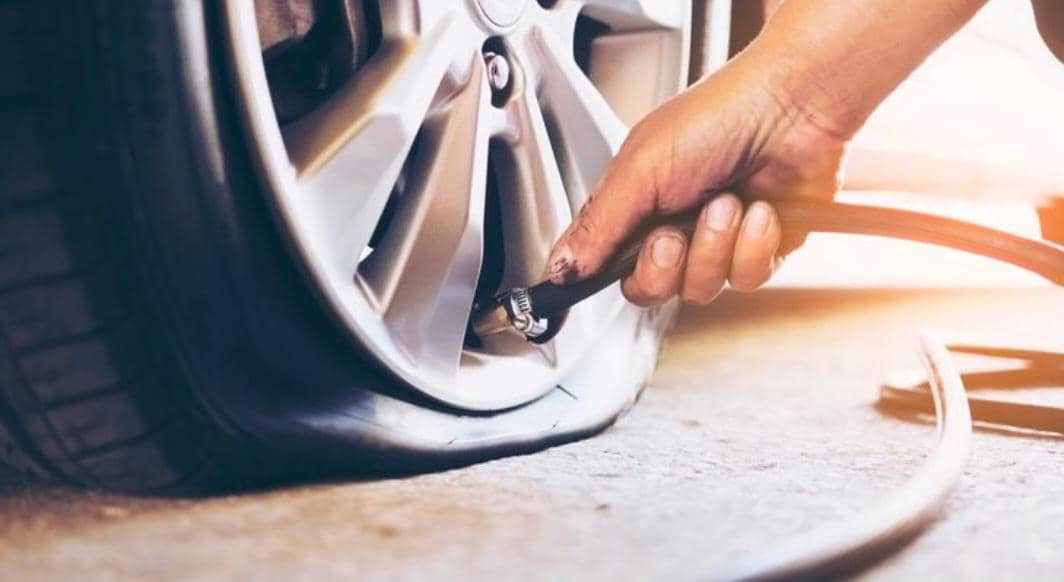 Ilustrasi pentil ban kendaraan dengan tutup hitam pada velg, menggambarkan kondisi kebocoran udara pada ban.