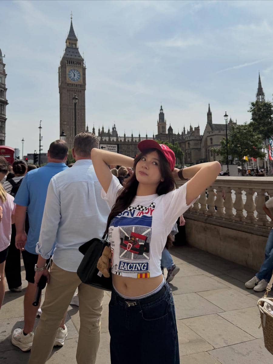 Azizi Asadel berjalan-jalan di sekitar Big Ben di London dengan latar menara jam ikonis kota tersebut.