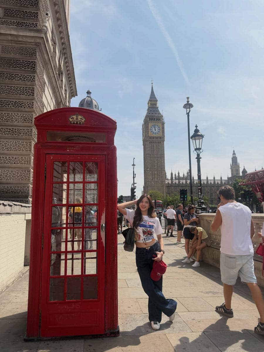Azizi Asadel berjalan di sekitar Big Ben di London, dengan menara jam ikonik dan gedung parlemen di latar belakang.