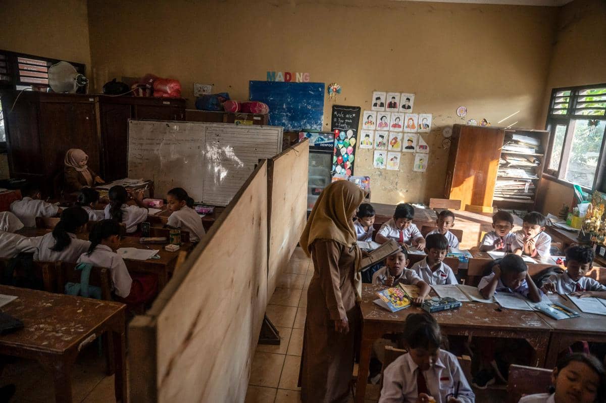 Sejumlah siswa kelas 3 dan 4 mengikuti kegiatan belajar mengajar di ruang kelas yang disekat akibat bangunan kelas ambruk di SD Negeri Tangg