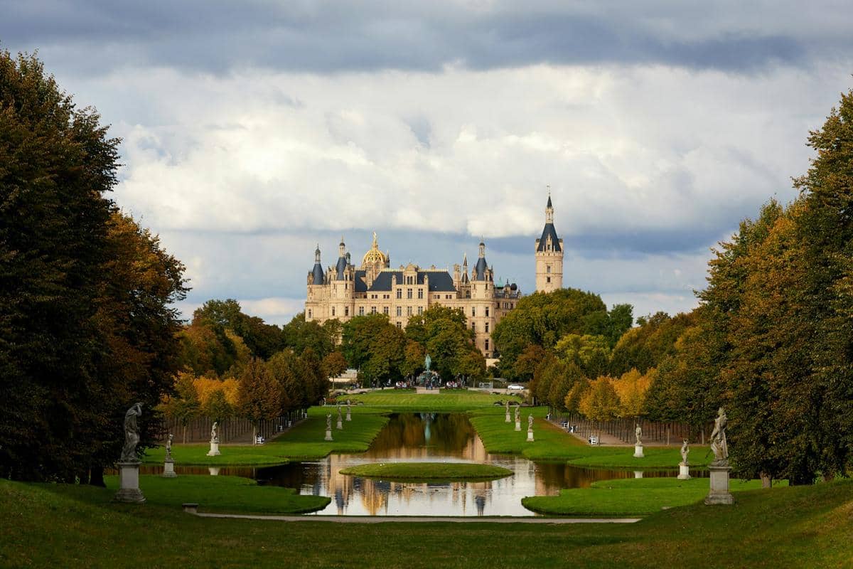 Kastil Schwerin di Jerman berdiri megah di tepi danau, dengan menara-menara runcing dan pepohonan di sekitarnya.