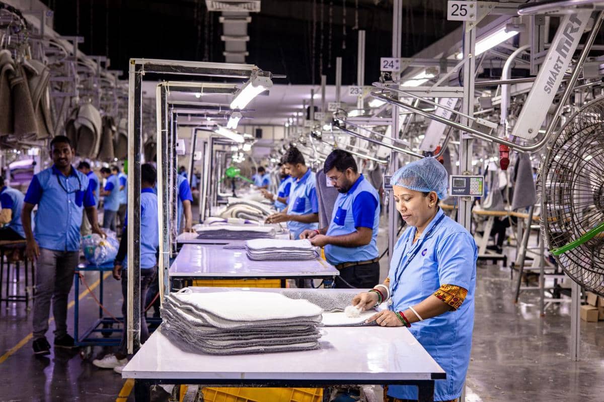 ilustrasi para pekerja di sebuah pabrik tekstil yang fokus pada produksi