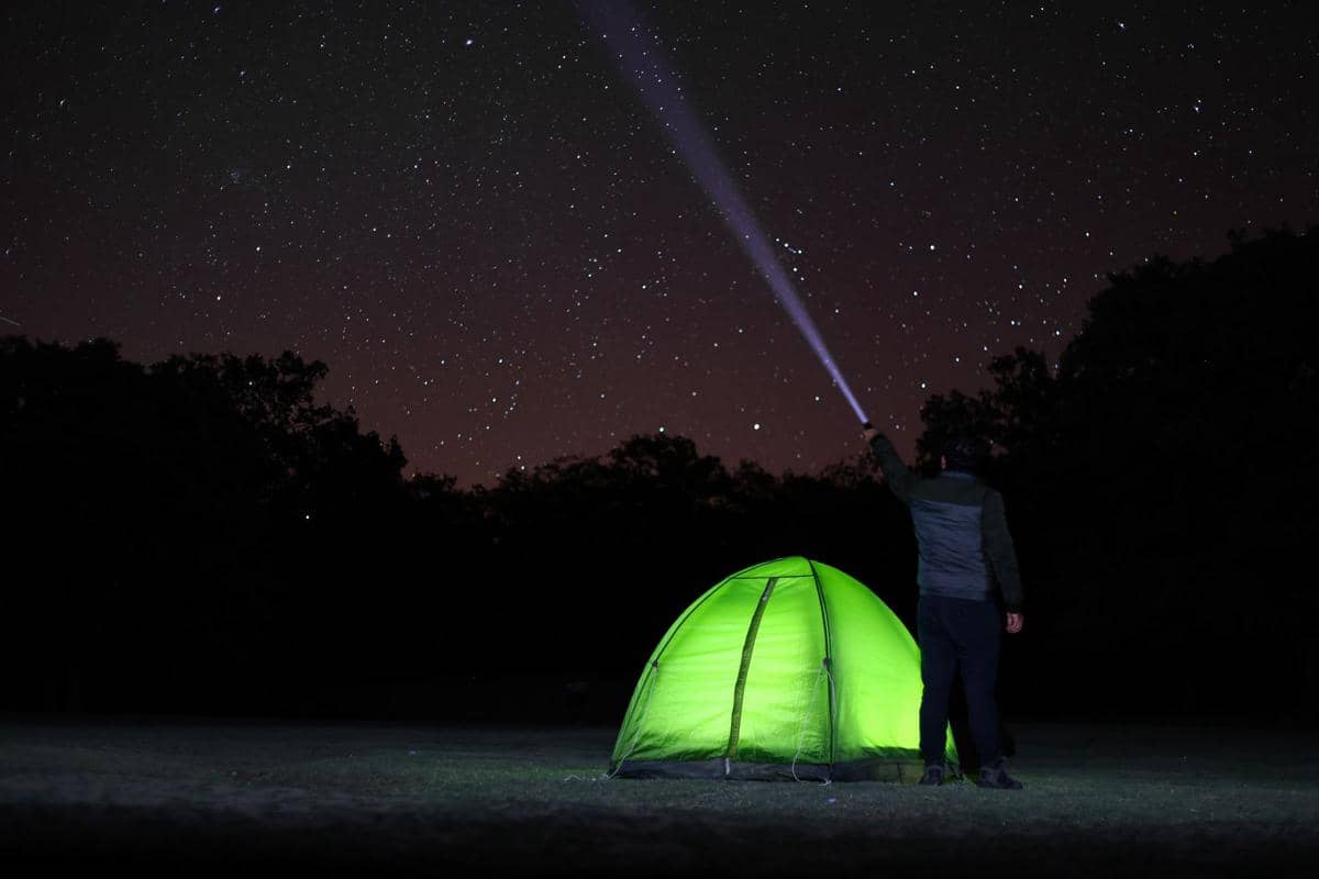 Menggunakan senter saat camping