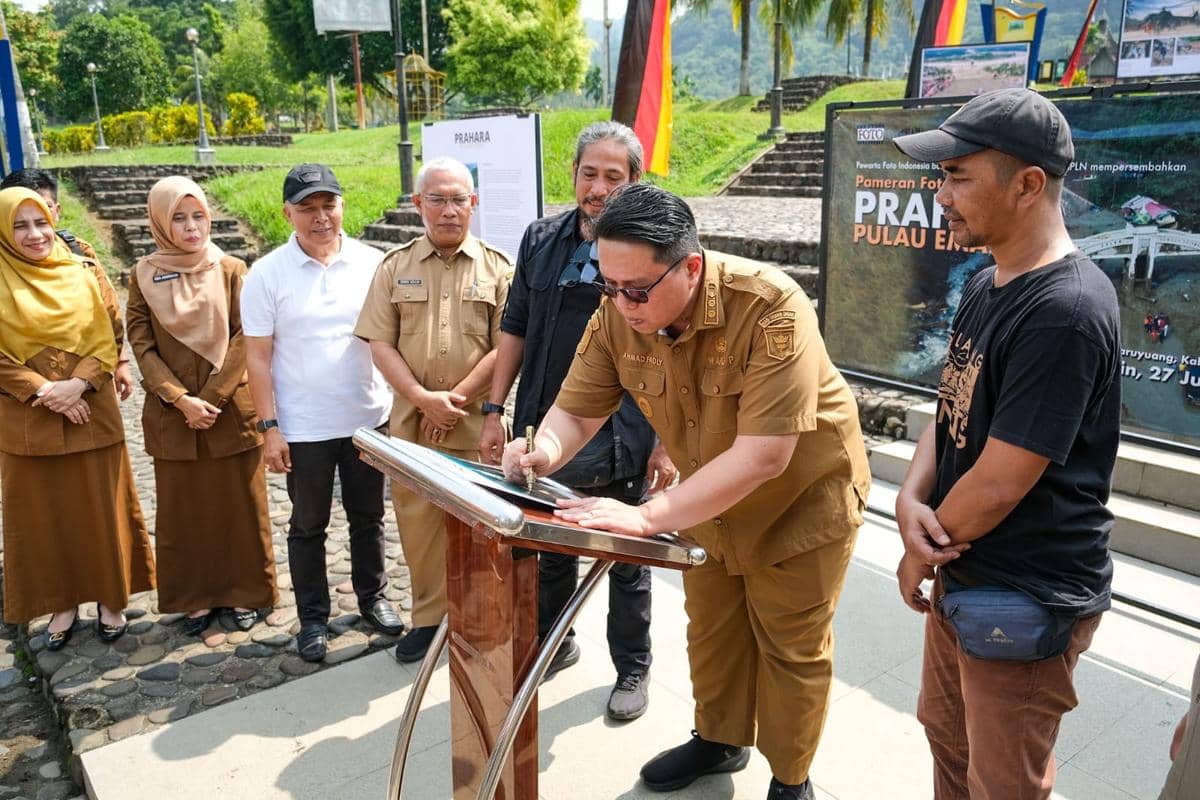Wakil Bupati Tanah Datar menandatangani buku foto Prahara Pulau Emas (Foto: PFI Padang)