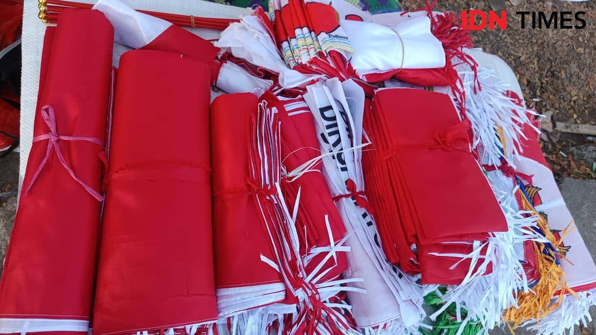 Seorang pedagang menata bendera Merah Putih dan aneka atribut kemerdekaan di Jalan Urip Sumoharjo, Makassar.
