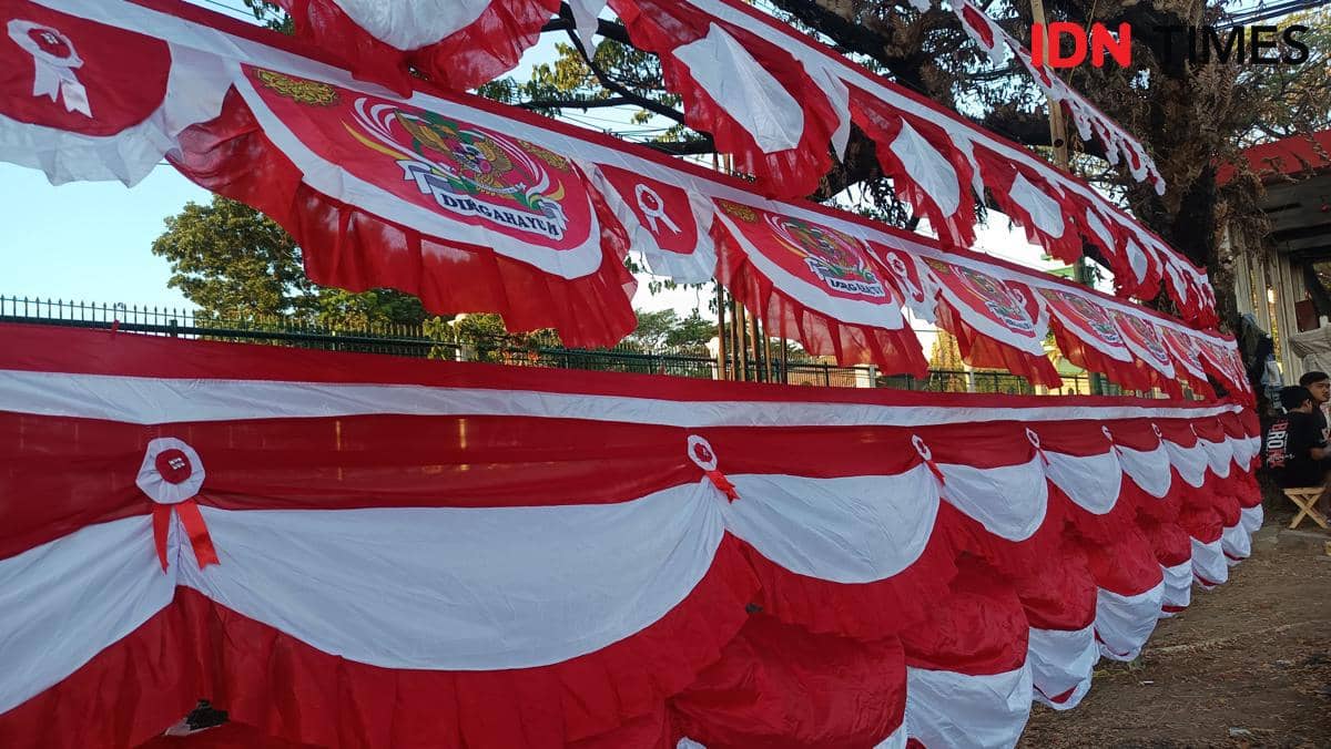 Pedagang menata bendera Merah Putih dan atribut kemerdekaan di lapak pinggir Jalan Urip Sumoharjo, Makassar.
