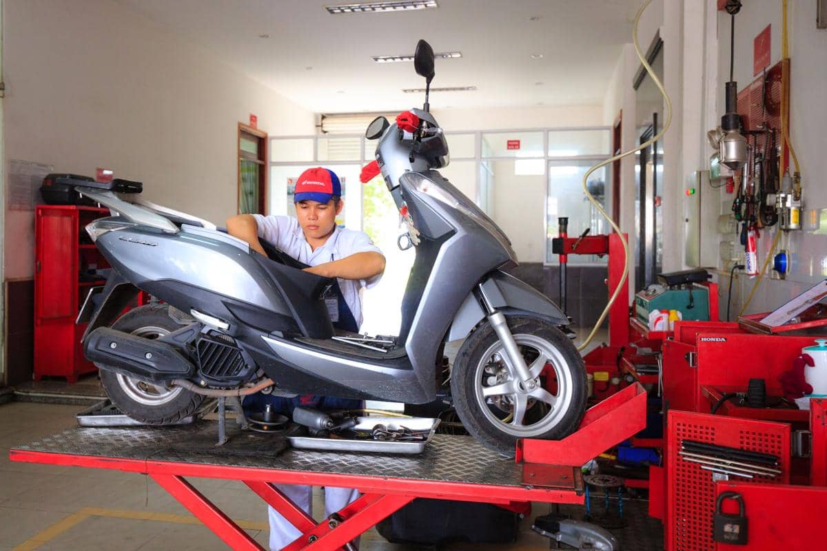 ilustrasi mekanik sedang membongkar dan membersihkan area CVT motor matic