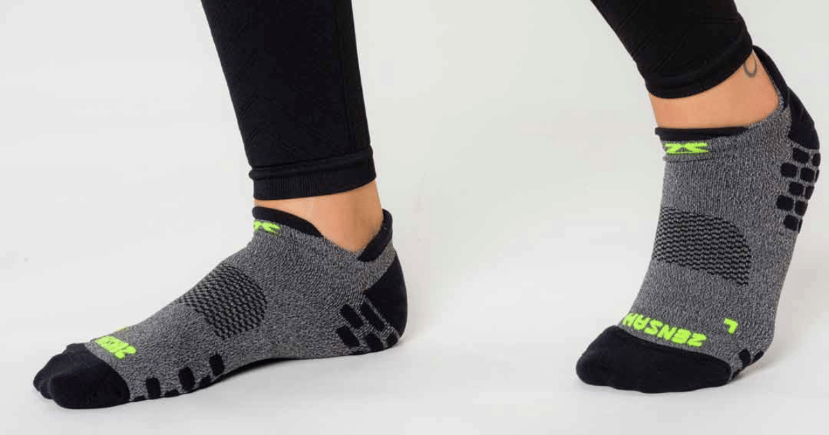 Sepasang kaos kaki olahraga Zensah berwarna putih dengan aksen biru dan logo merek pada bagian atas yang terlihat jelas.