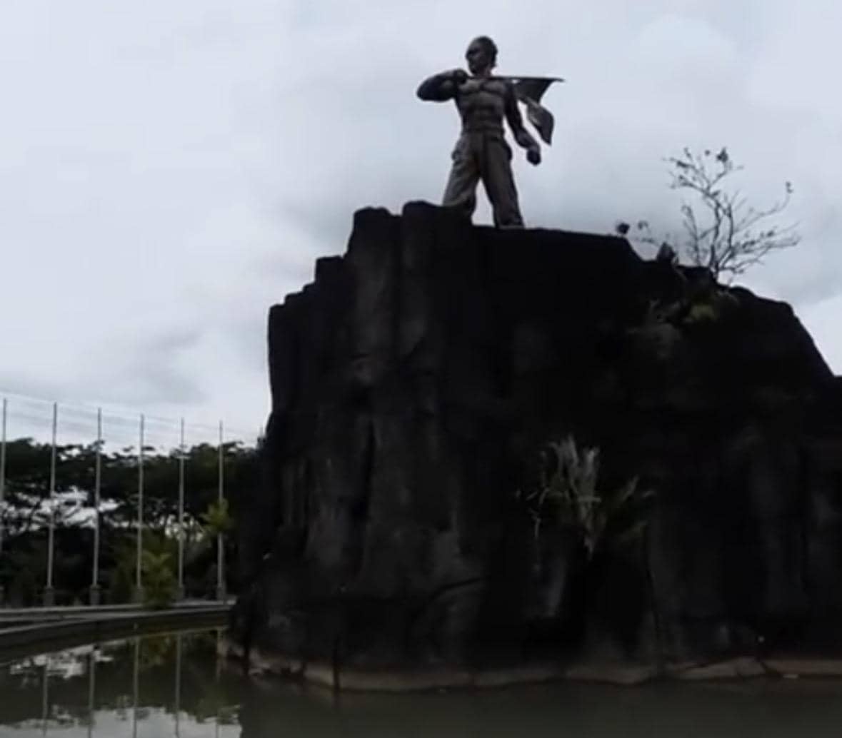 Bundaran tugu di Melawi dengan monumen di tengah jalan, dikelilingi pepohonan dan ruang terbuka di sekitarnya.