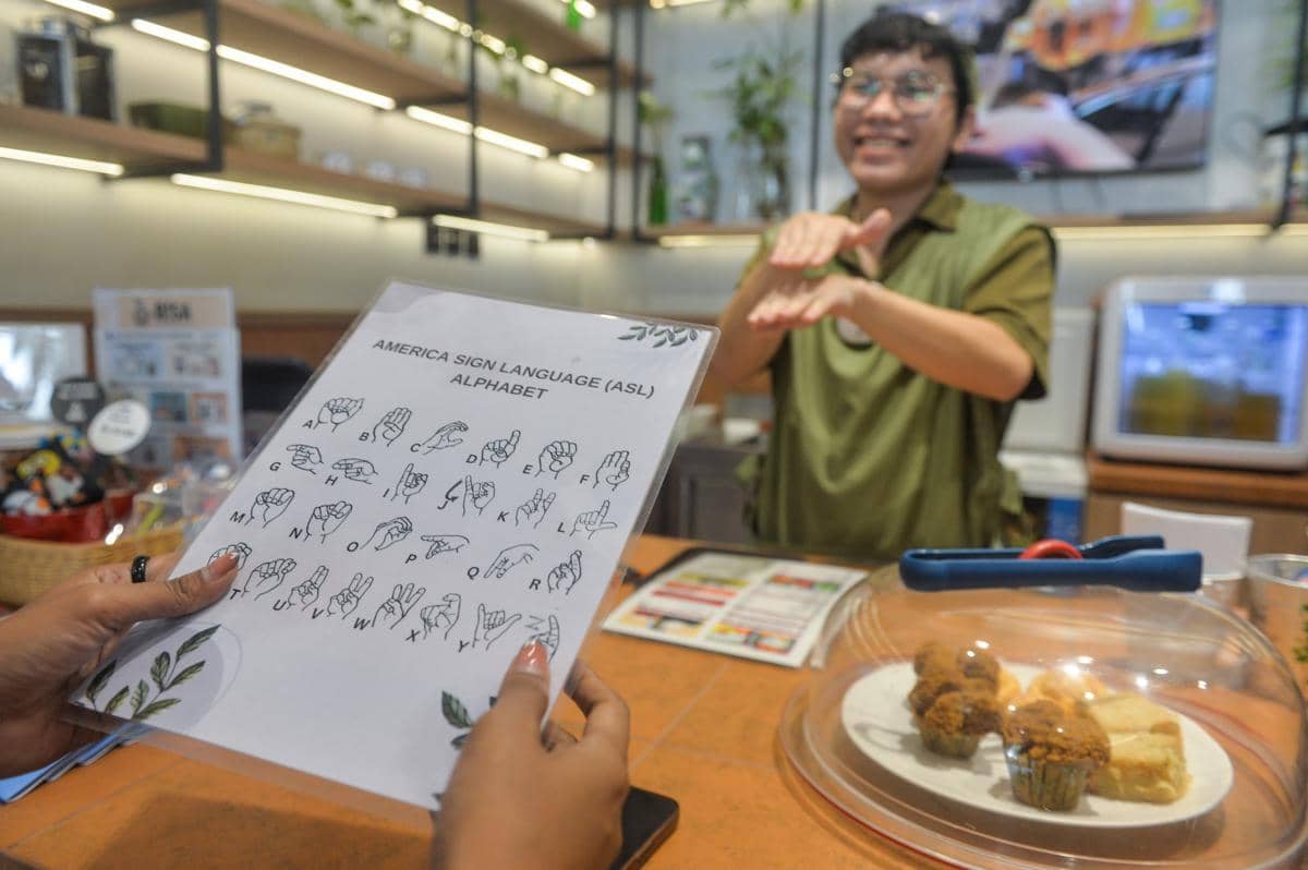 Barista penyandang tunarungu melayani pengunjung menggunakan bahasa isyarat di Bisa Cafe, Kota Tangerang. (ANTARA FOTO/Putra M. Akbar)
