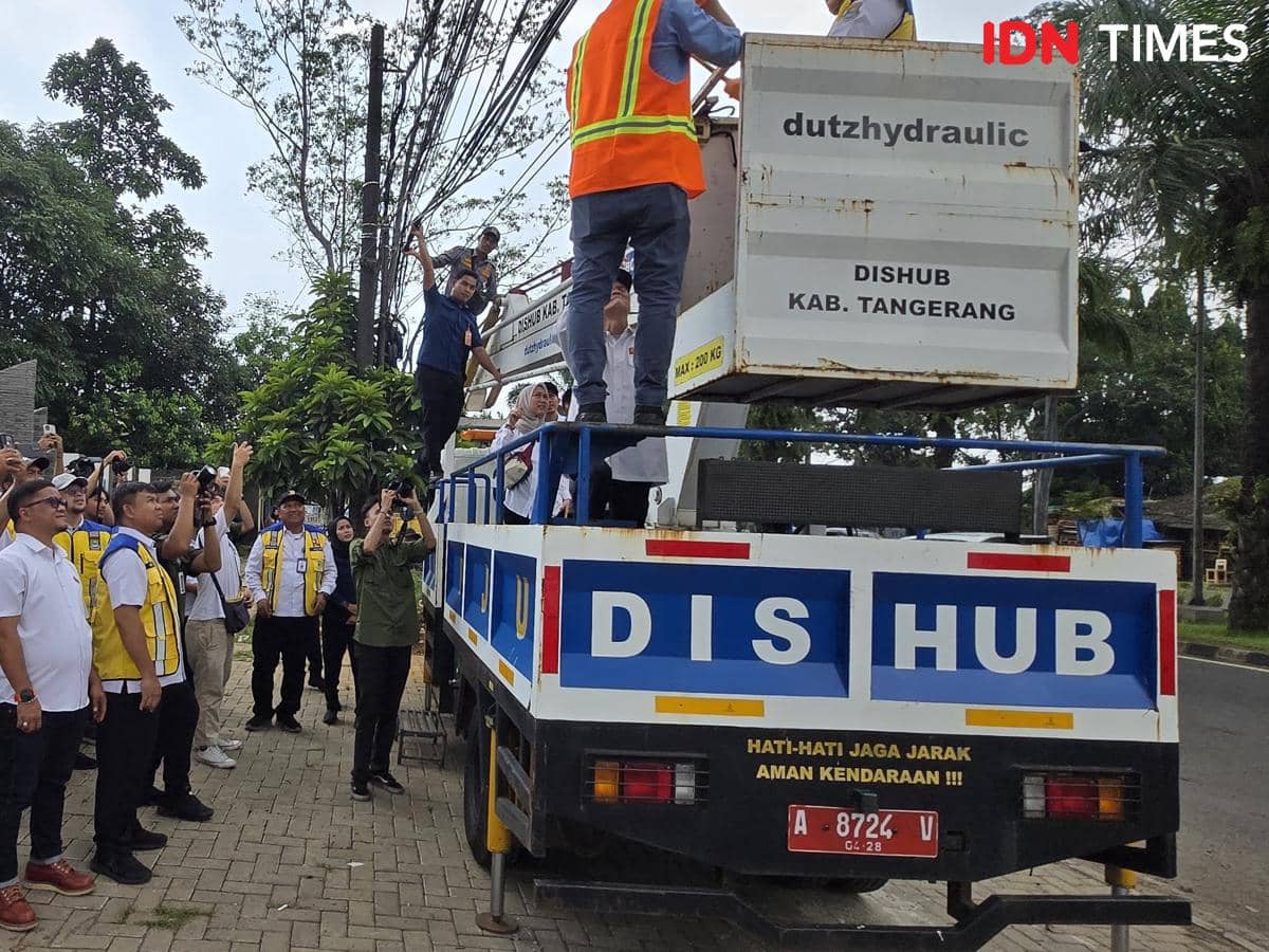 Wakil Bupati Tangerang Intan Nurul Hikmah memotong kabel udara dalam proses pemindahan jaringan ke bawah tanah.