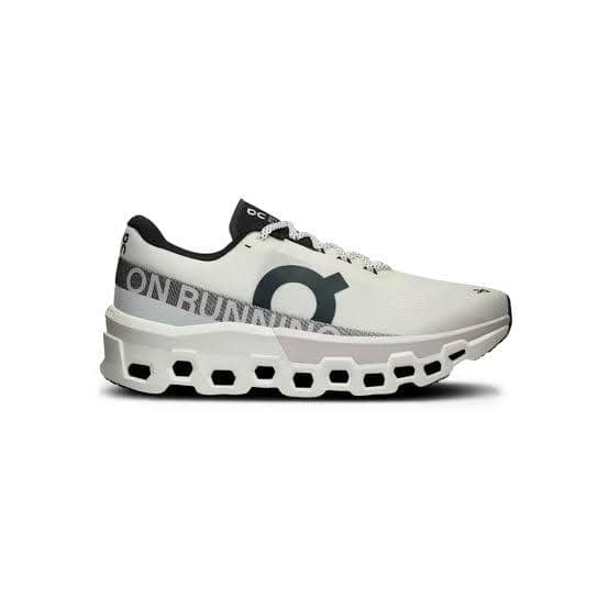 Sepatu lari On Cloudmonster 2 berwarna hitam dengan sol tebal berongga, dipotret dari sisi samping di latar putih.