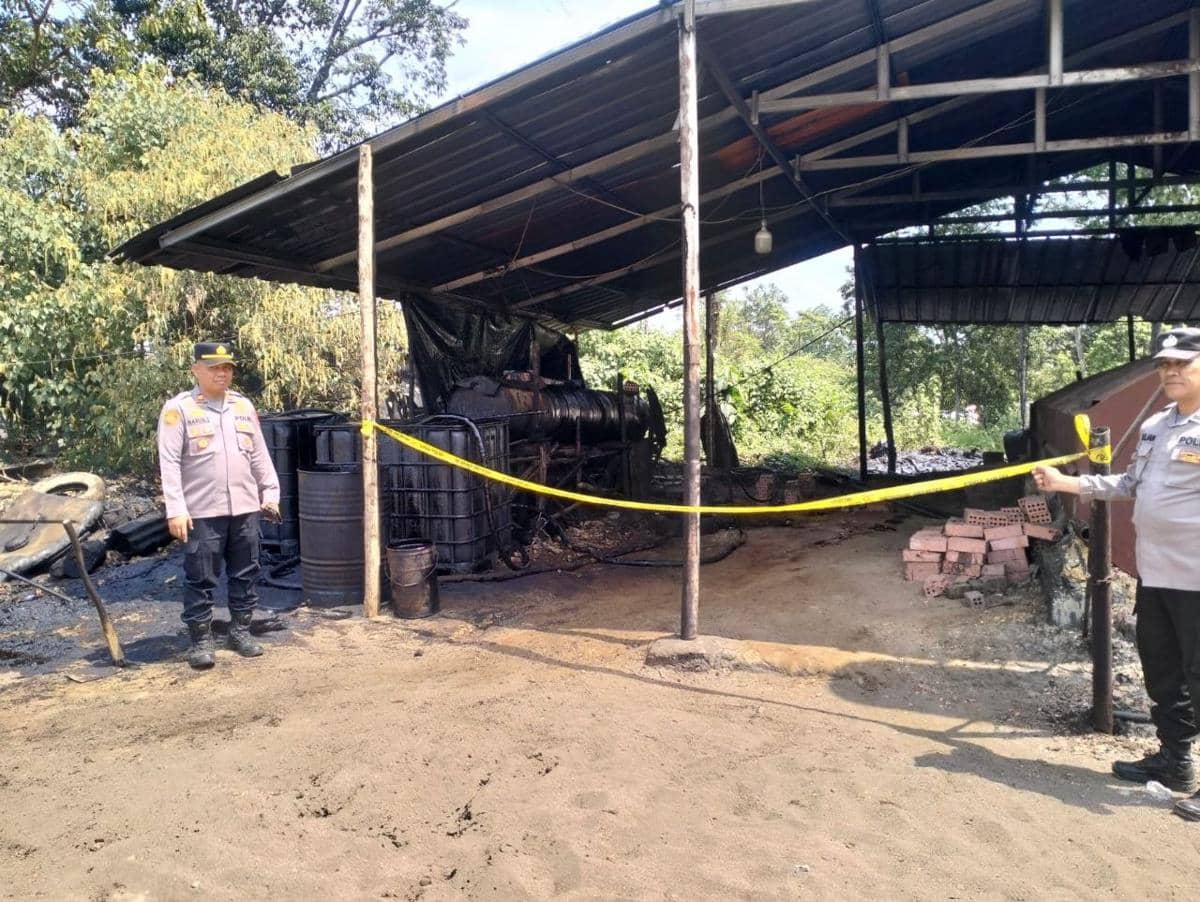 Personel Polsek Sanga Desa memasang garis polisi pada salah satu lokasi penyulingan minyak mentah ilegal (illegal refinery) yang digerebek d