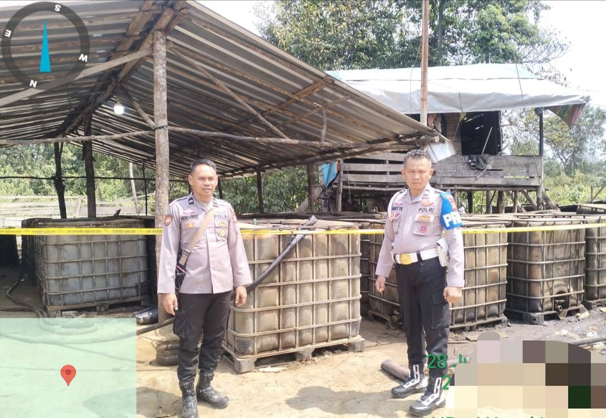Personel Polsek Sanga Desa memasang garis polisi pada salah satu lokasi penyulingan minyak mentah ilegal (illegal refinery) yang digerebek d
