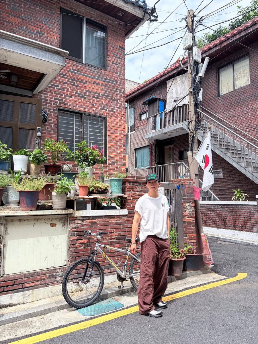 Ok Jin Wook mengenakan outfit kasual untuk nongkrong dengan paduan busana santai bergaya modern dan rapi.
