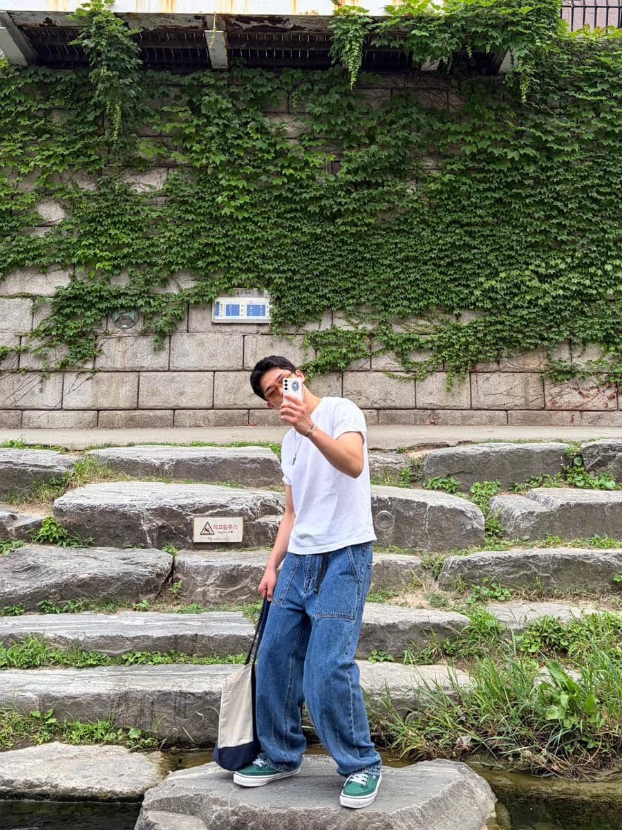 Ok Jin Wook tampil dengan outfit kasual untuk nongkrong sambil berpose santai di area luar ruangan.