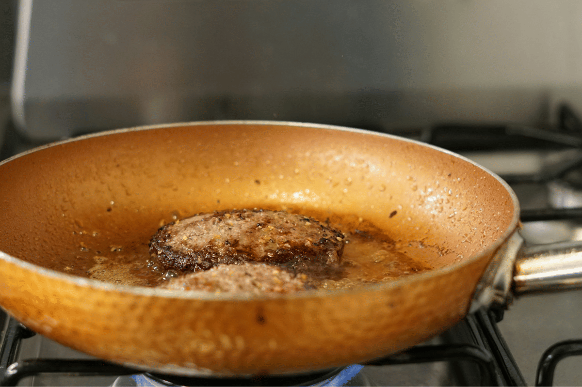 Ilustrasi proses membuat steak hache dari daging cincang yang dibentuk menjadi patty dan dimasak hingga matang.