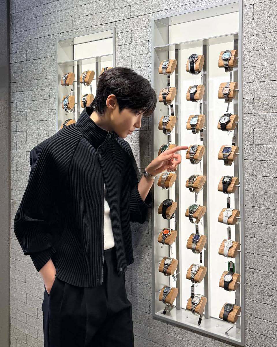 Hwang In Yeop mengenakan kemeja putih dan celana hitam untuk tampilan clean outfit pria yang rapi dan kasual.