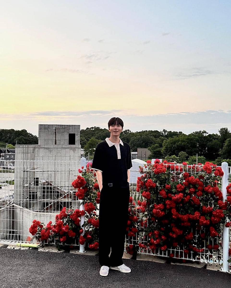 Hwang In Yeop tampil dengan outfit clean bernuansa netral, memadukan atasan sederhana dan celana panjang.