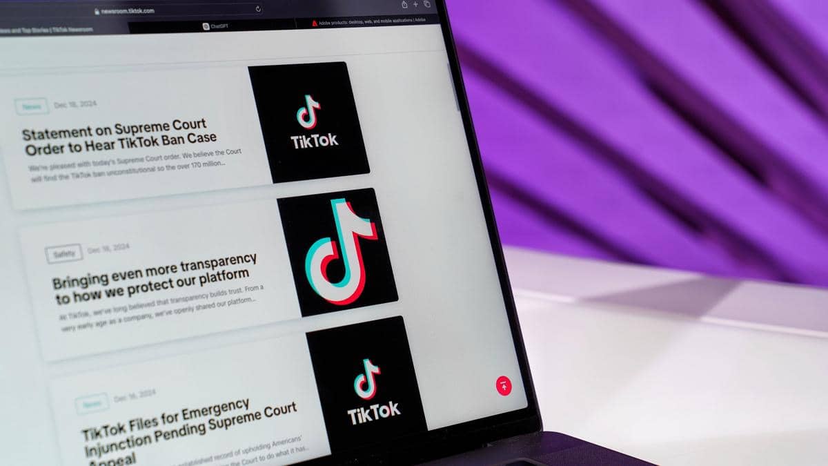 Tampilan dekat layar laptop yang menunjukkan artikel berita TikTok dengan latar belakang ungu.