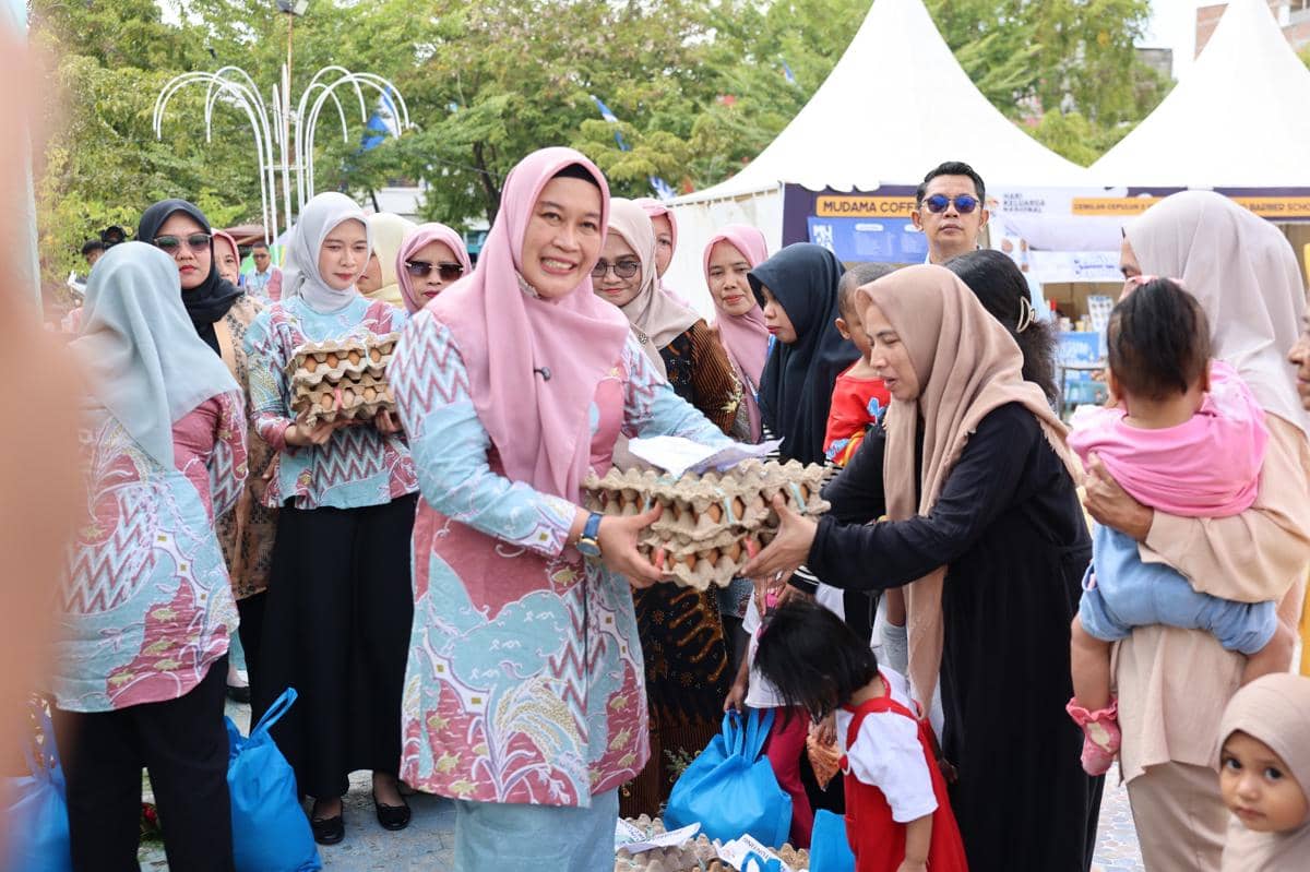 Kepala Perwakilan BKKBN Provinsi Sulawesi Selatan, Fatmawati sat menyerahkan bantuan sembako kepada warga di puncak HARGANAS Sulsel 2026 di Wajo, Kamis (30/7/2026). Dok. BKKBN Sulsel