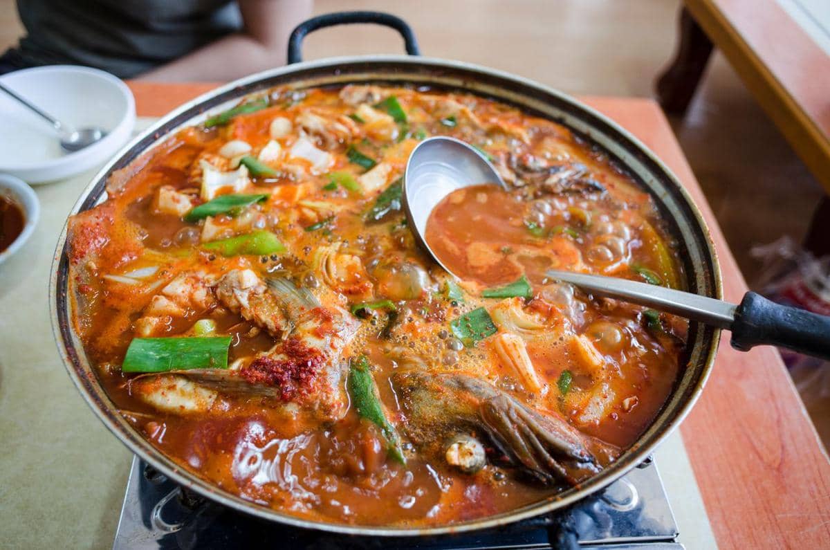 Ilustrasi semangkuk sup kimchi sebagai hidangan hangat khas Korea yang disajikan dalam sebuah mangkuk.
