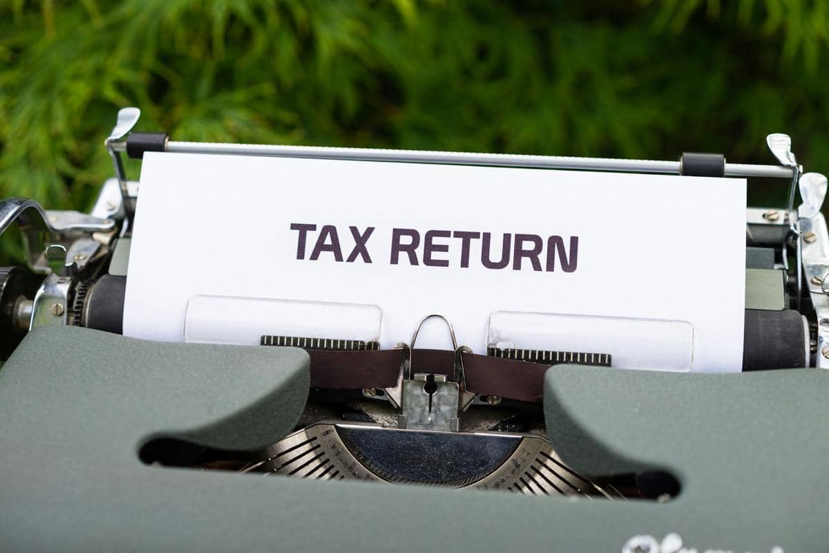 Ilustrasi dokumen pajak bertuliskan Tax Return pada mesin tik.
