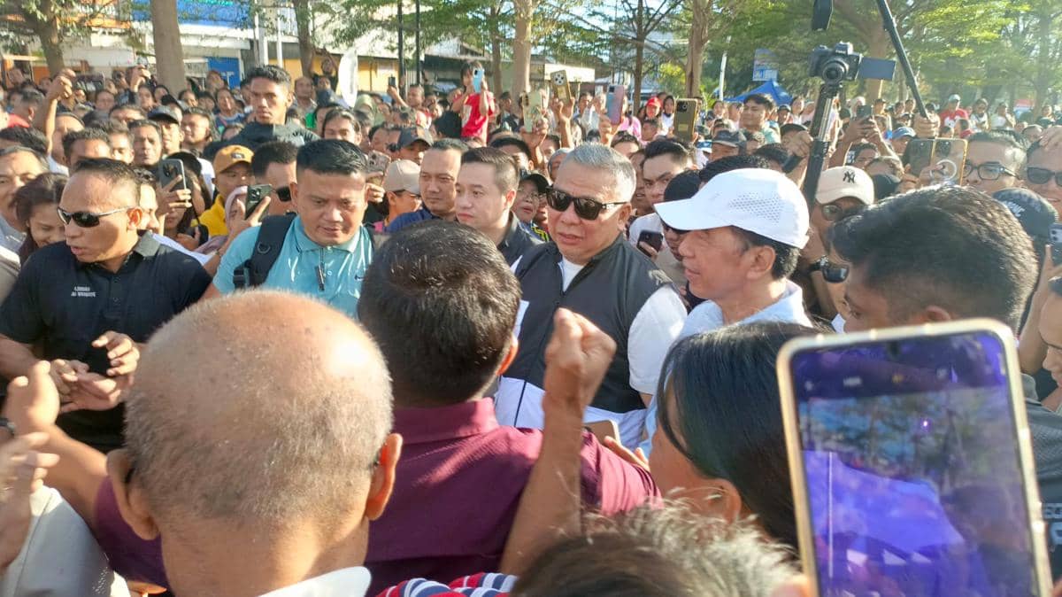 Presiden Jokowi dikerumuni warga yang antusias di arena Car Free Day Kota Kupang, dengan banyak orang berada di sekelilingnya.