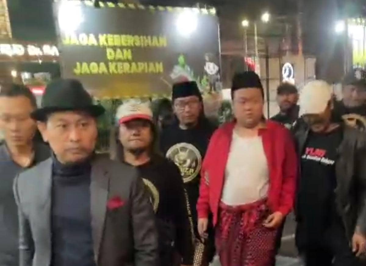 Seorang pria berkemeja merah didampingi petugas saat diserahkan kepada Satreskrim Polresta Malang Kota.