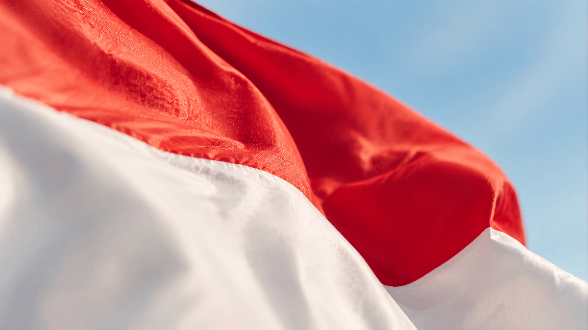 Close-up bendera merah putih Indonesia berkibar di langit biru