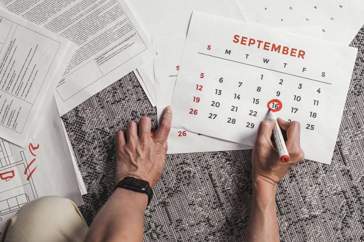 ilustrasi seseorang memegang kalender dengan tanggal September yang dilingkari