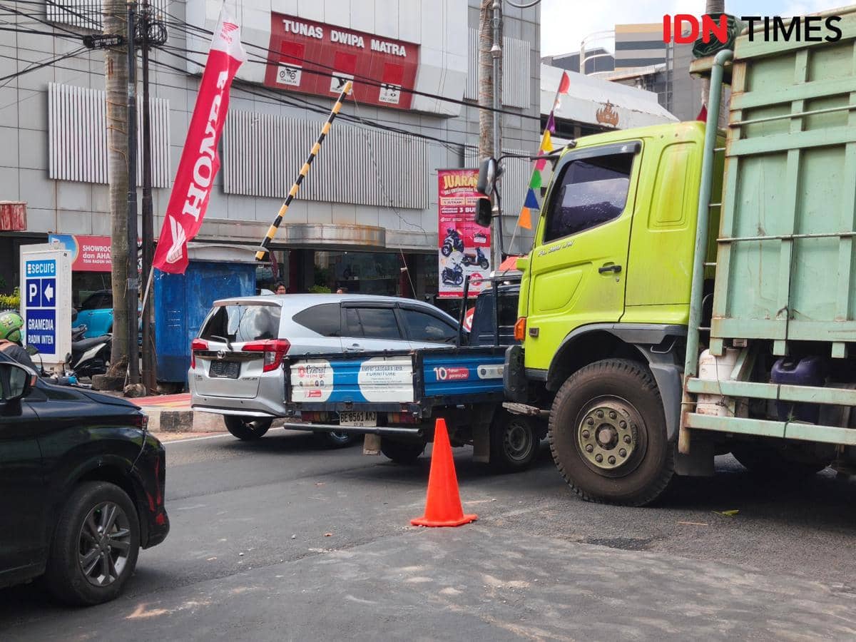 Cor Ambrol, Truk Bermuatan Hebel Melintang di Jalan Radin Inten