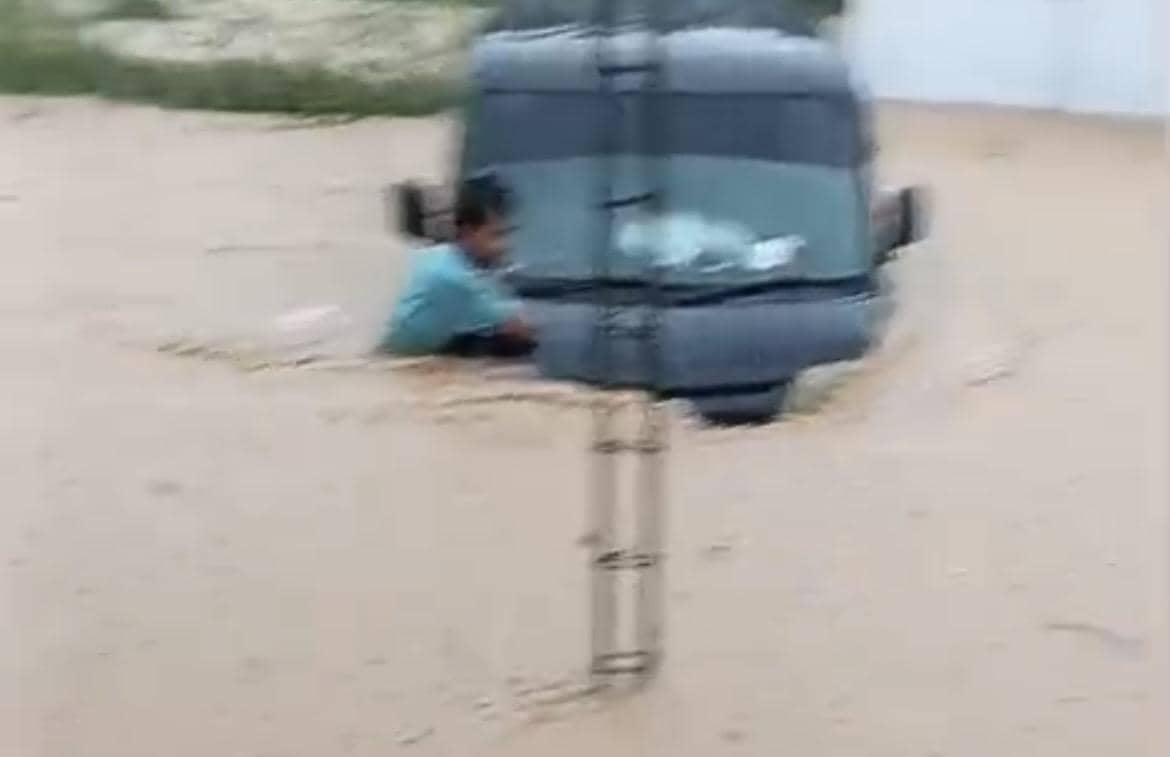 Seorang warga di Kota Padang mencoba menyelamatkan mobilnya yang terendam banjir (Foto: Istimewa)