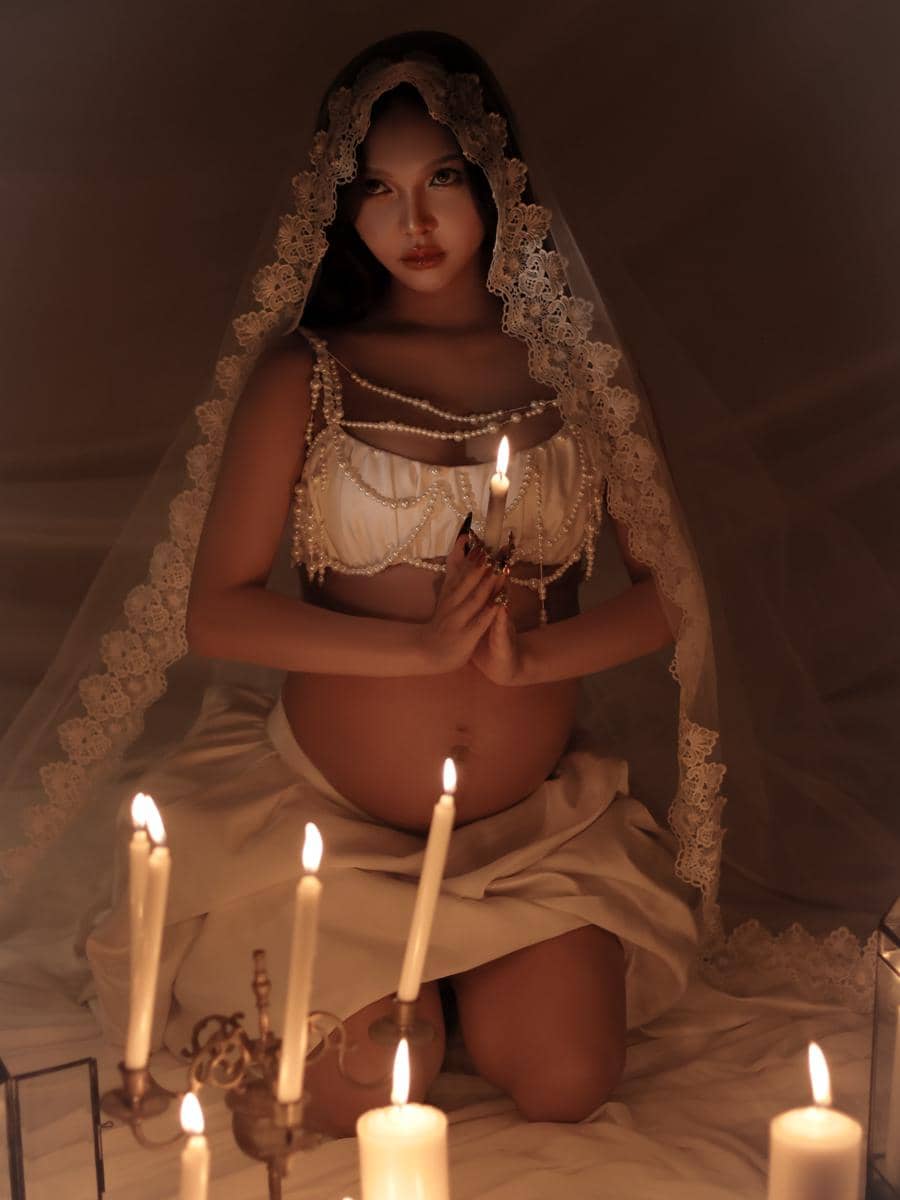Potret maternity Meyden dalam sesi pemotretan kehamilan dengan pose yang menonjolkan perutnya sebagai fokus.