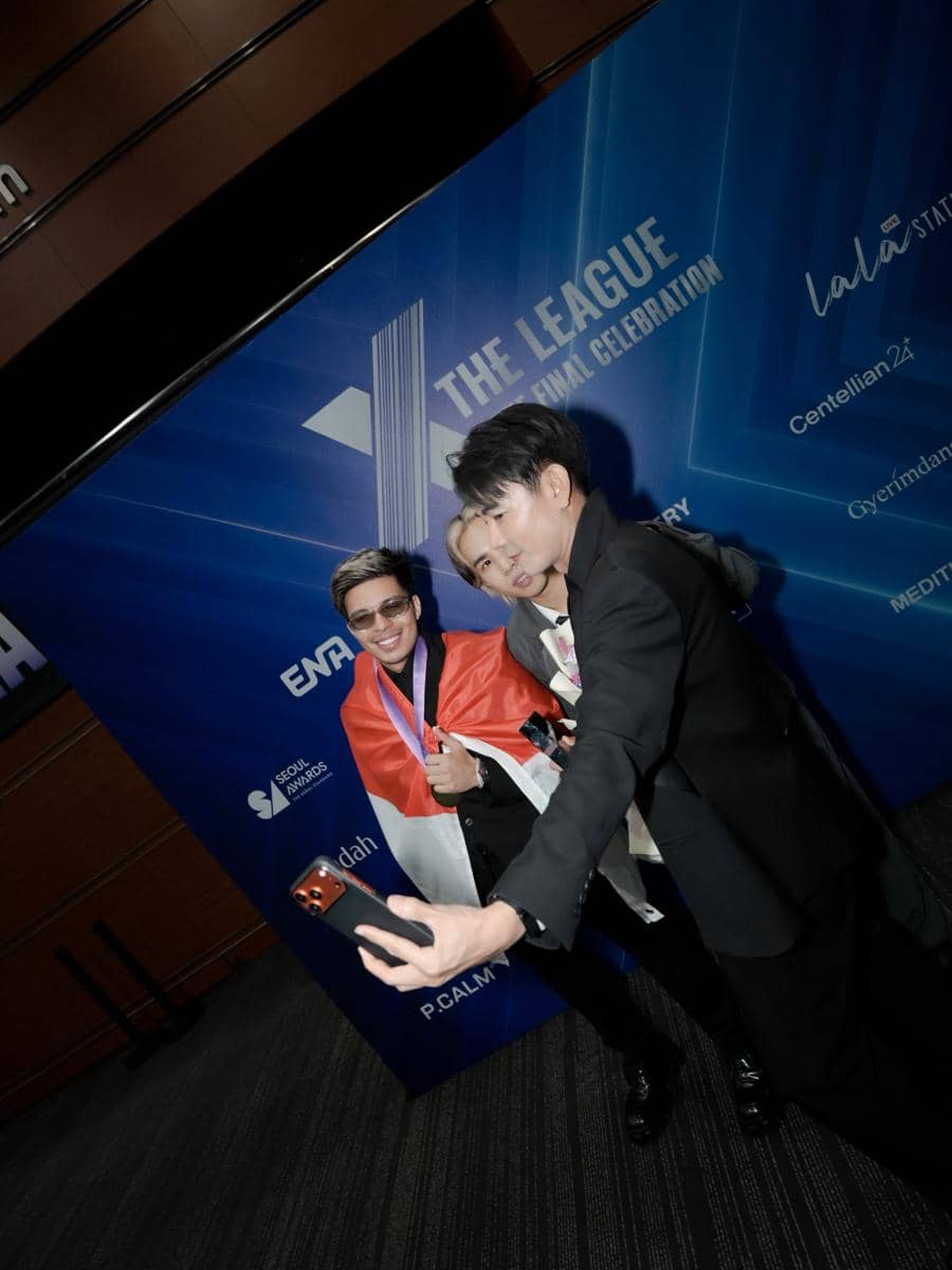 Atta Halilintar memegang plakat penghargaan dari X The League sambil tersenyum di depan latar gelap.