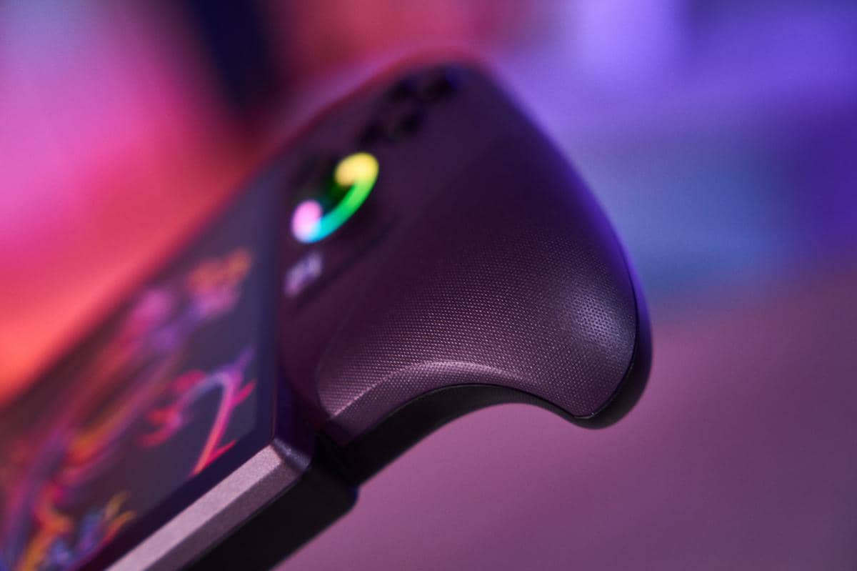 Perangkat gaming genggam Claw 8 AI Plus berwarna krem dengan layar menyala dan kontrol di kedua sisi.