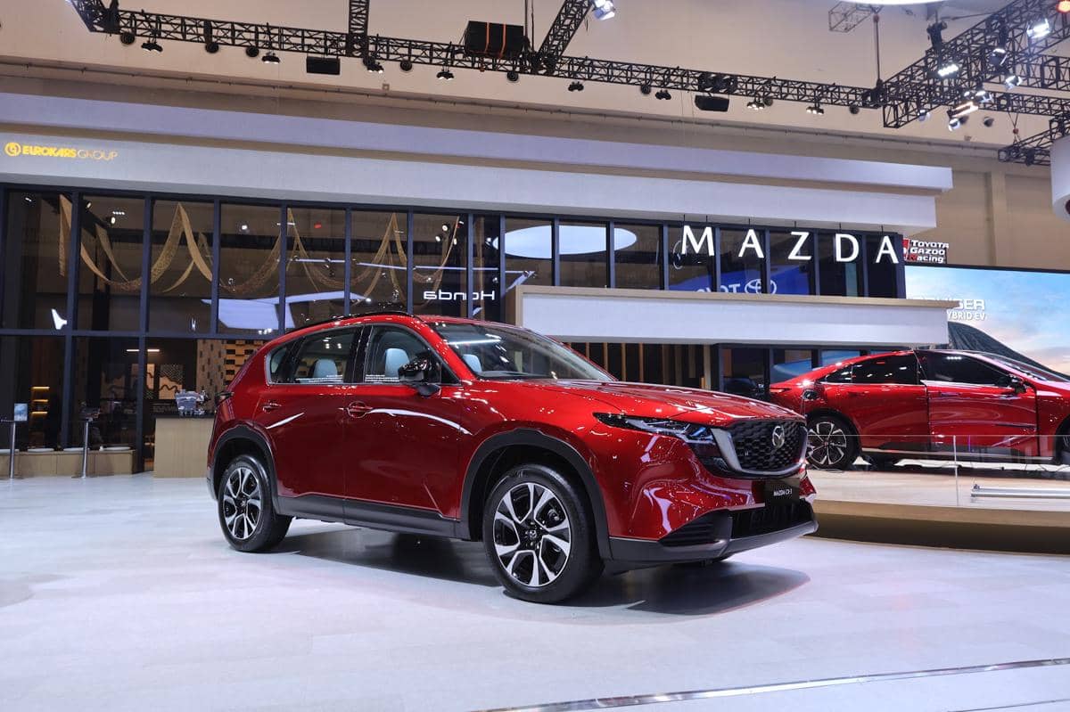 Tampilan eksterior Mazda CX-5 terbaru dengan desain matang dan modern, menonjolkan grille depan serta lampu ramping.