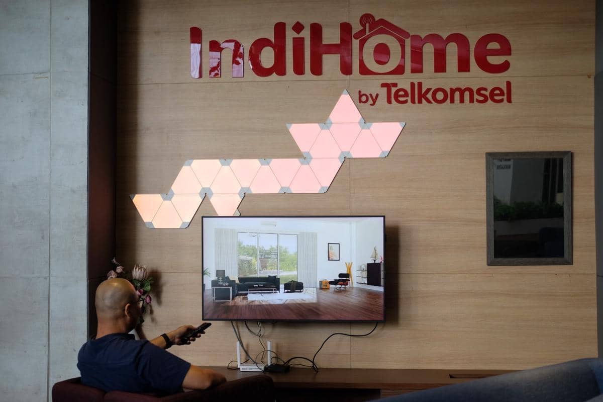 Seorang warga menikmati layanan IndiHome by Telkomsel di rumah. ()
