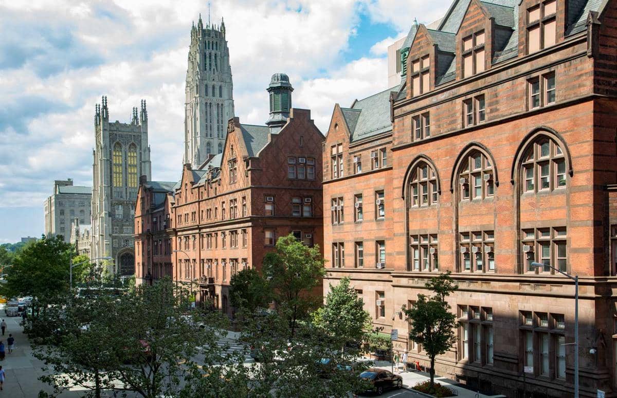 Fasad gedung Teachers College di Columbia University terlihat dengan dinding bata, jendela tinggi, dan pepohonan.