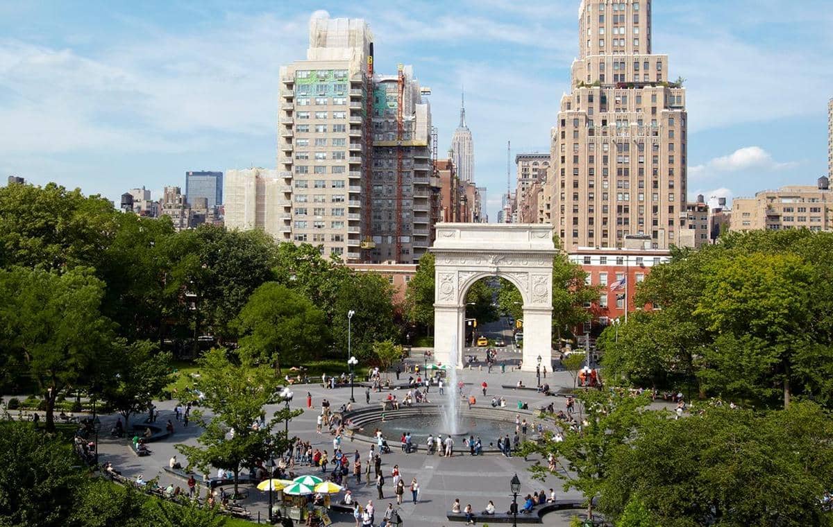 Logo New York University (NYU) dengan obor putih khas universitas pada latar berwarna ungu.