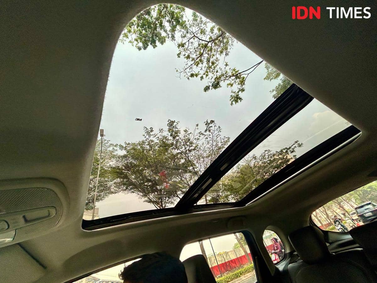 Atap panoramik Suzuki Grand Vitara terlihat dari dalam kabin, dengan panel kaca lebar membentang di atas penumpang.