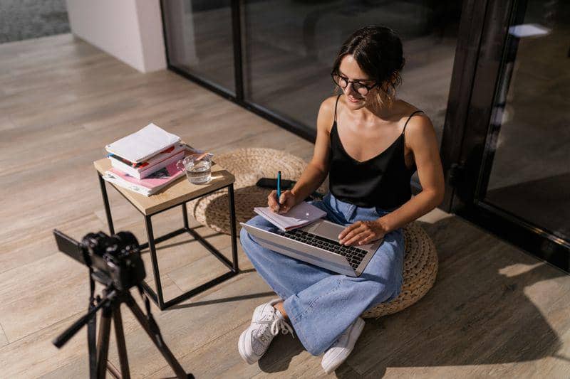 Ilustrasi AI Content Creator membuat konten digital menggunakan laptop dengan bantuan AI.