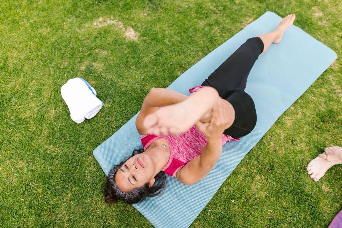 Ilustrasi gerakan supine hamstring stretch untuk meregangkan otot paha belakang sambil berbaring telentang.