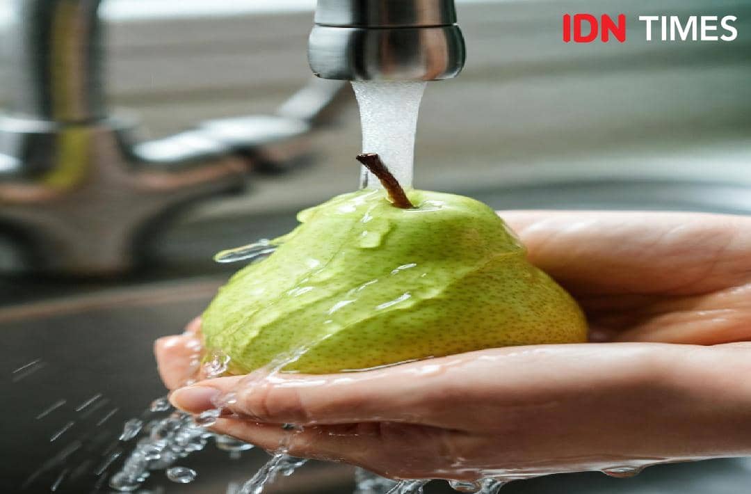 Sejumlah buah pir berwarna hijau kekuningan tersusun, disarankan dicuci terlebih dahulu sebelum dimakan.