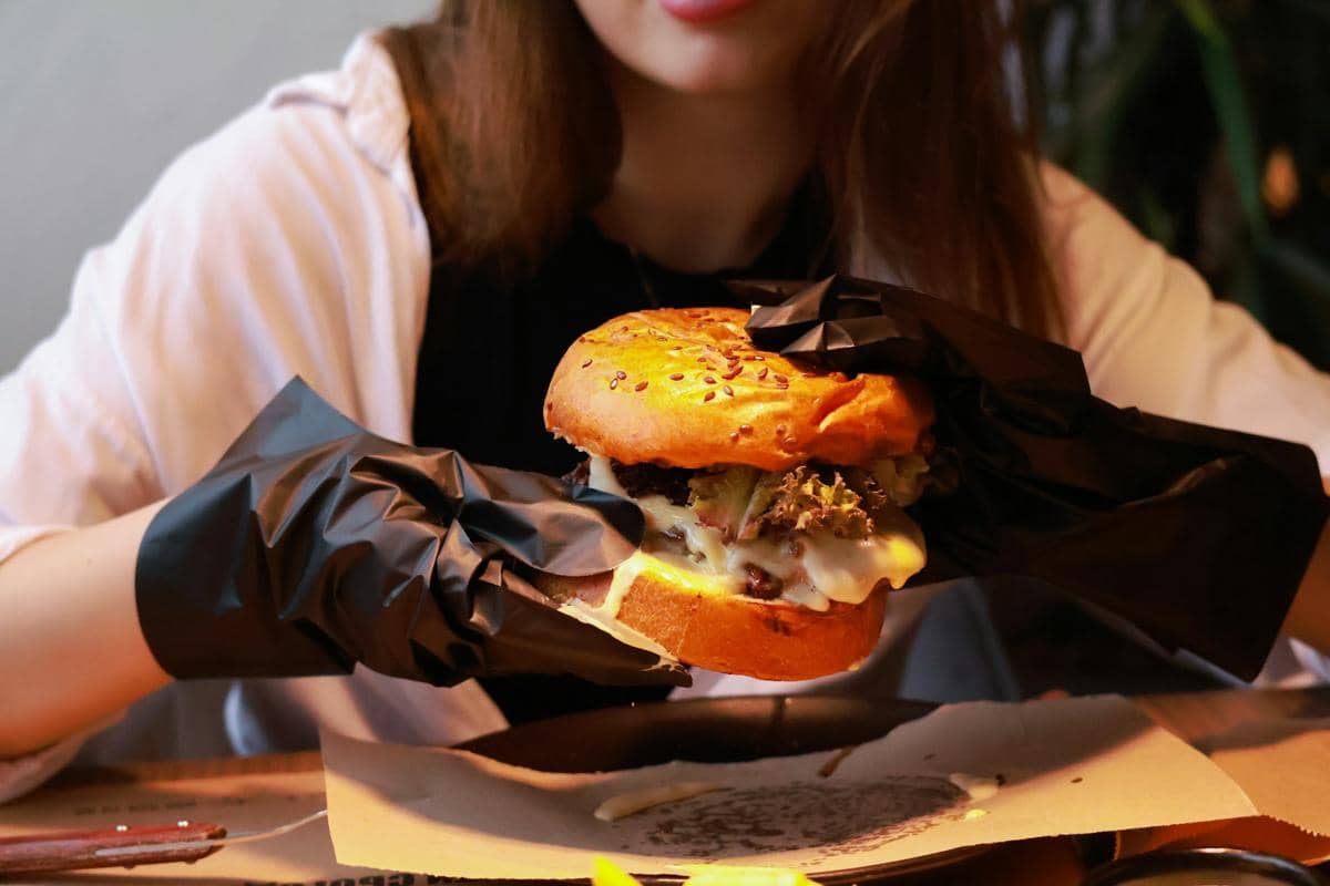 Burger hatch chile dengan roti bun, patty, sayuran, dan lelehan keju sebagai ilustrasi hidangan yang menggugah selera.