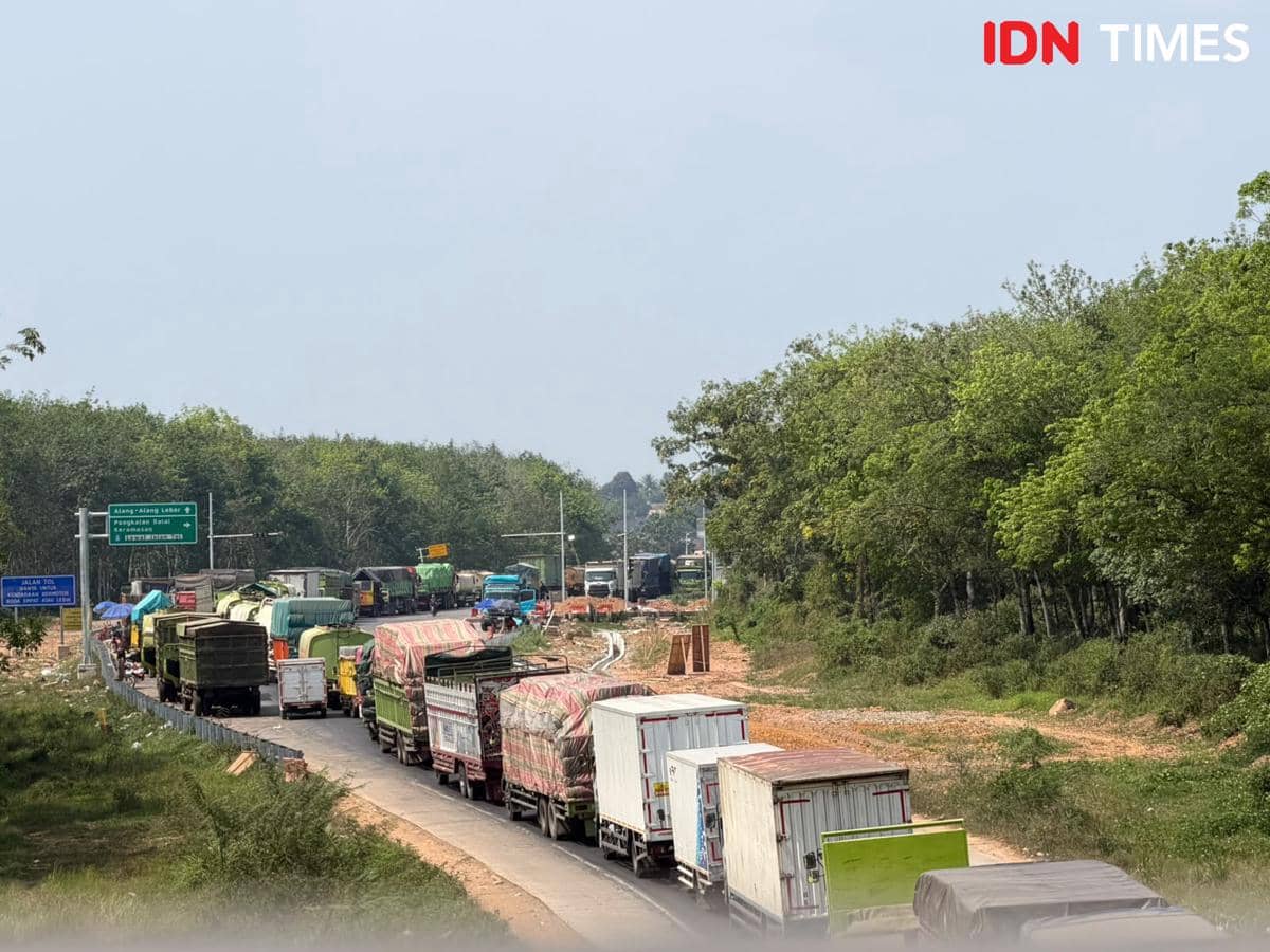 Antrean kendaraan mengular memenuhi Jalan Lintas Timur ruas Palembang-Betung, menggambarkan kondisi kemacetan lalu lintas.