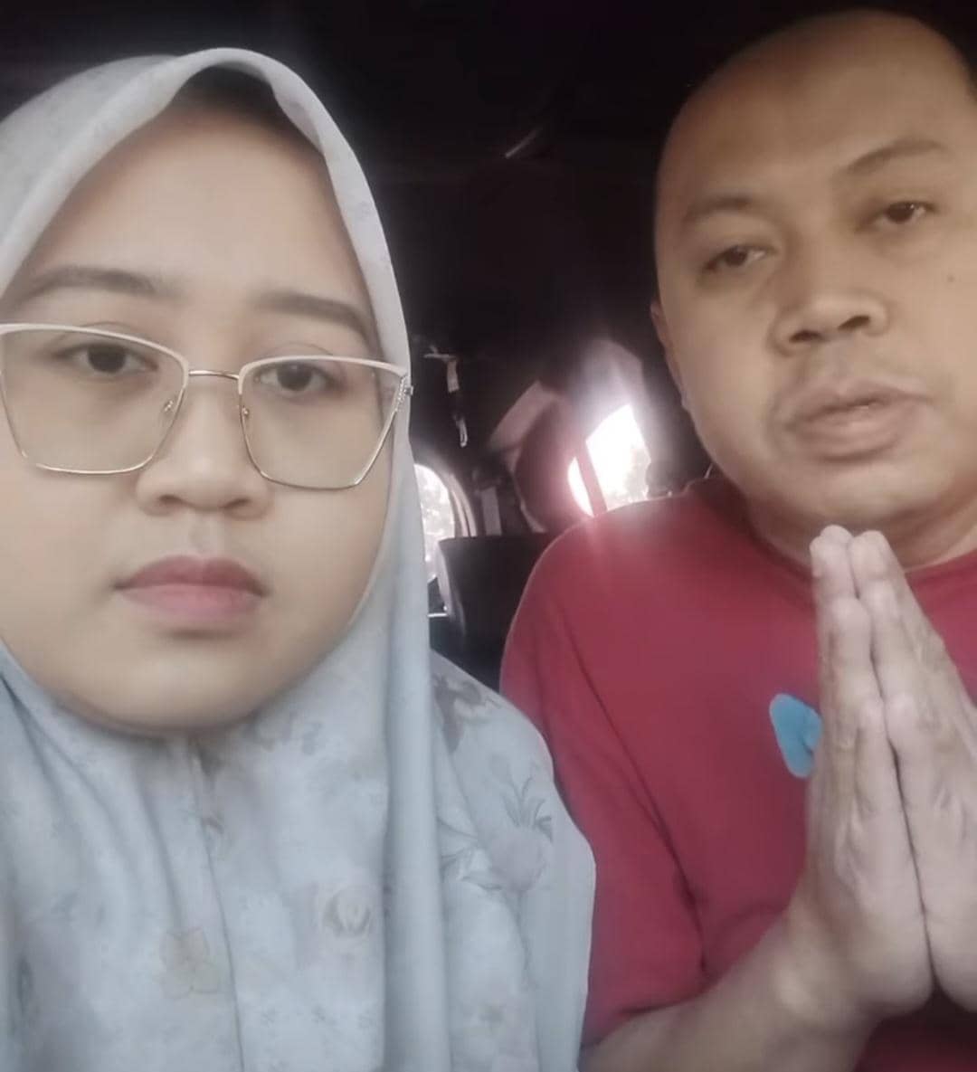 dr Herdiana dan Angga duduk berdampingan saat merekam video berisi permintaan maaf di dalam ruangan.