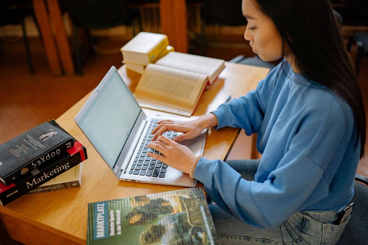seorang mahasiswa menggunakan laptop