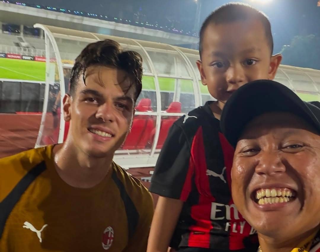Oki Rengga dan Arthur berfoto bersama beberapa pemain AC Milan di lapangan saat sesi latihan klub berlangsung.